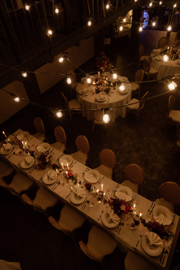 Wedding reception table decorated with flowers, candles, and fine table settings.