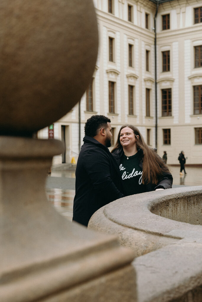 Intimate marriage proposal in front of the historic architecture of Prague Castle