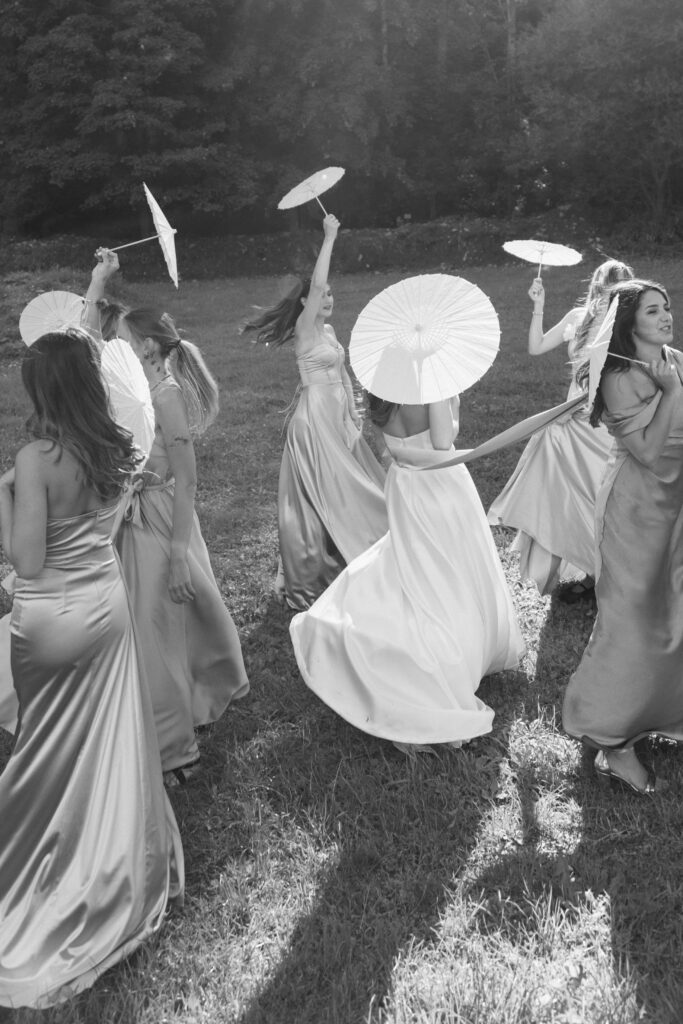 black and white photo of the Bride and her bridesmaids dancing in the nature