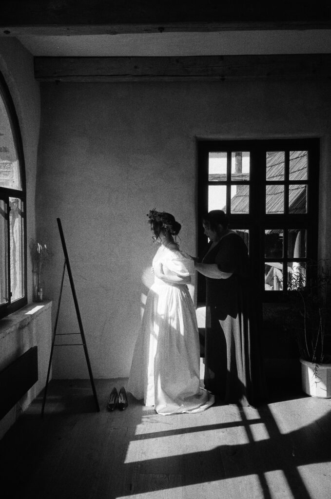 bride with her mother is preparing for the wedding ceremony captured on film by lucie muse