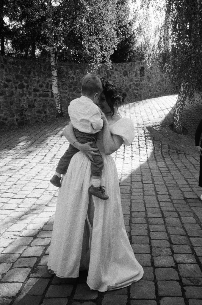 bride and her child on her wedding day on 35 mm by lucie muse