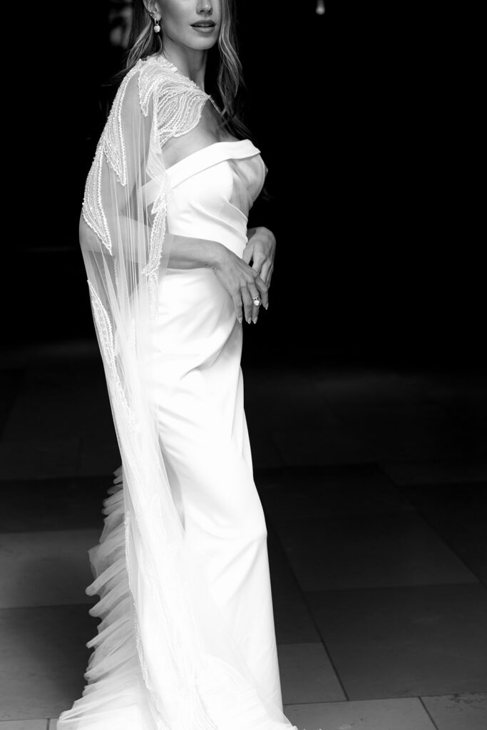 Black and white fashion-forward bridal portrait showcasing a minimalist wedding gown and veil.