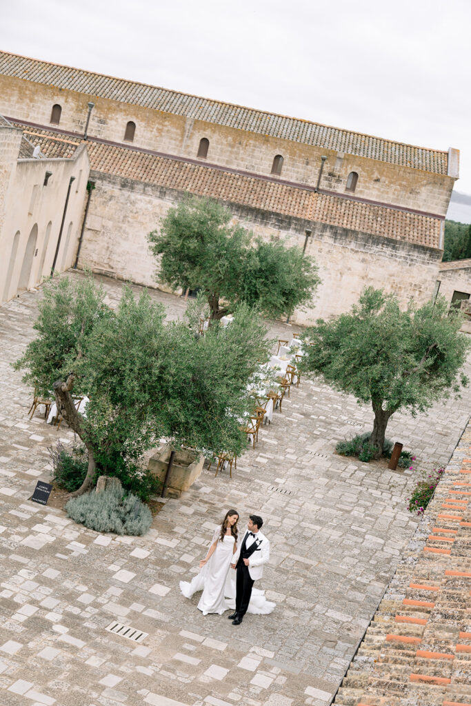 Wide aerial shot of outdoor wedding ceremony setup surrounded by olive trees at Relais Histò.