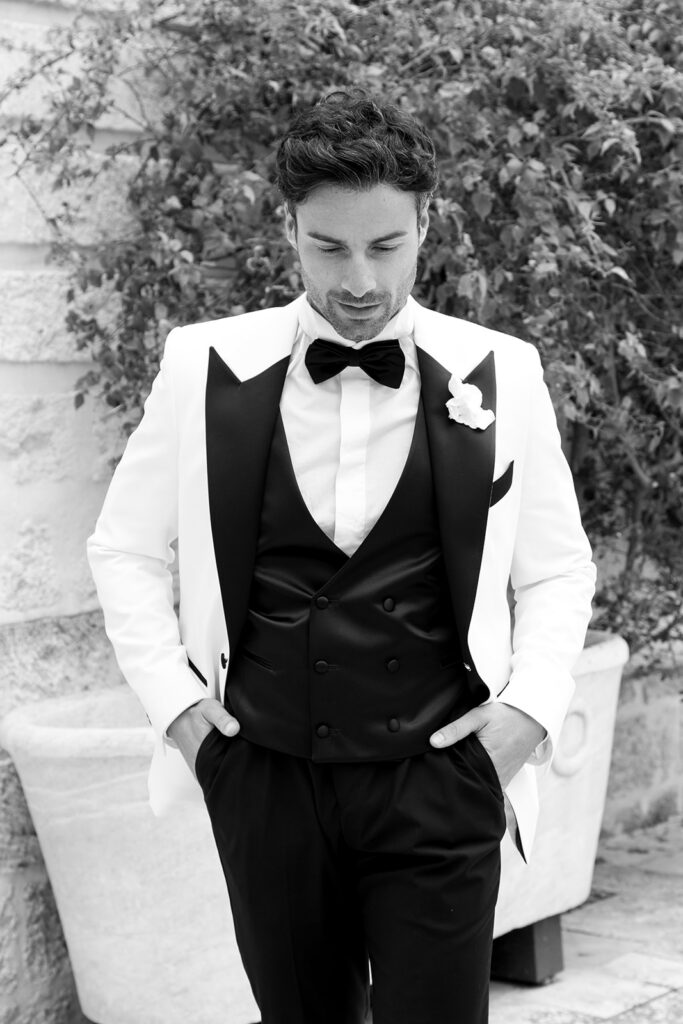 Editorial black and white portrait of a groom in a classic black and white tuxedo.